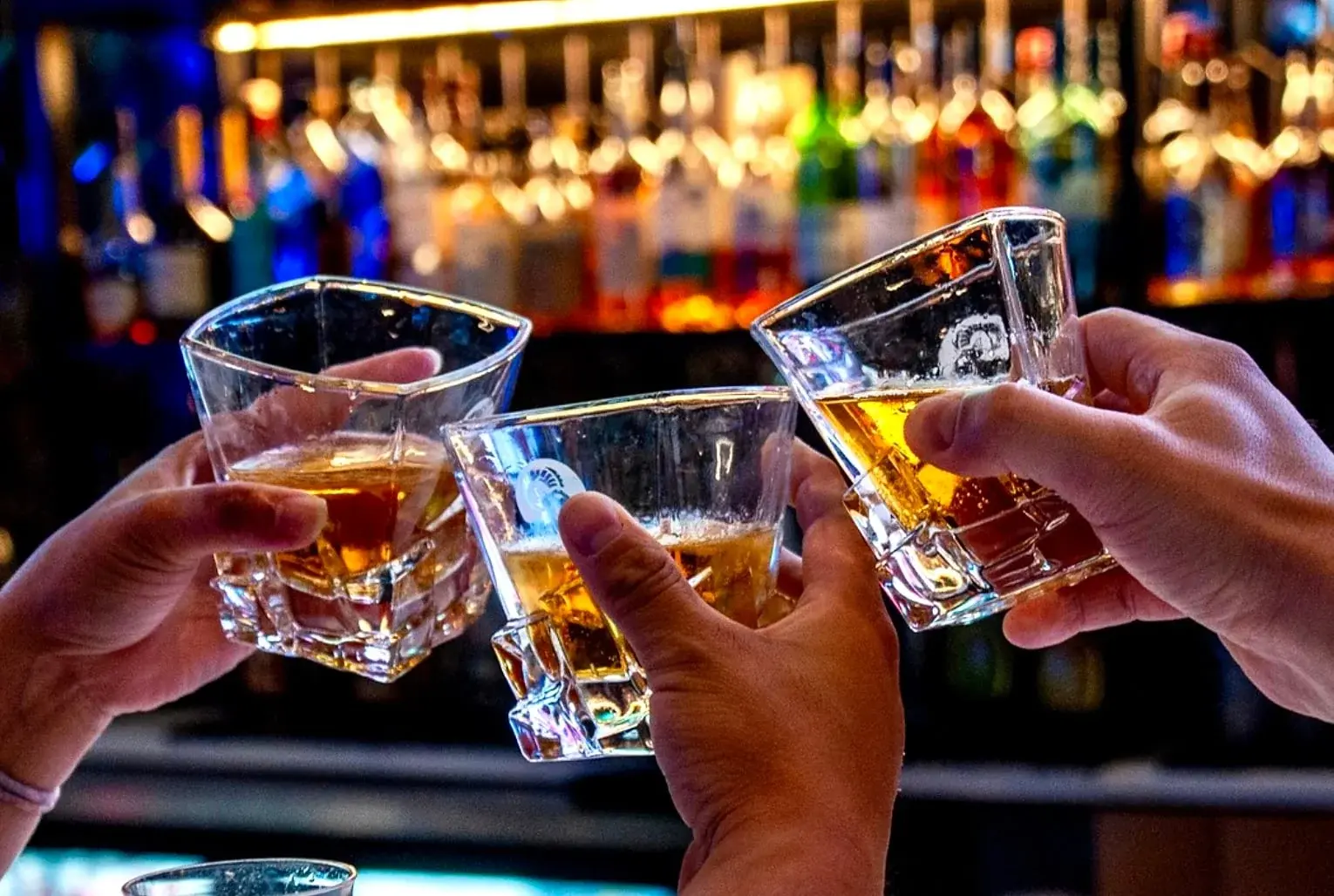 Group of friends toasting drinks at a bar