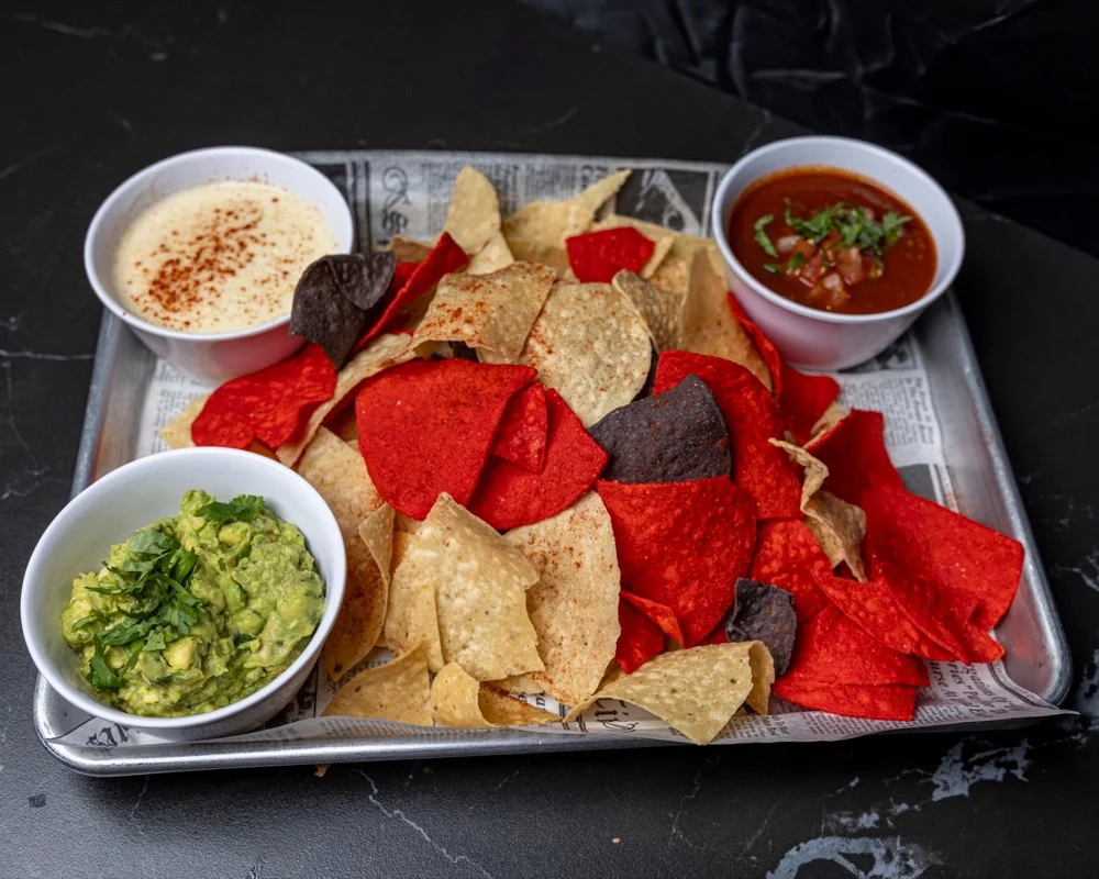 Chips with guacamole, salsa, and queso — classic game day appetizers at G.O.A.T's Arena